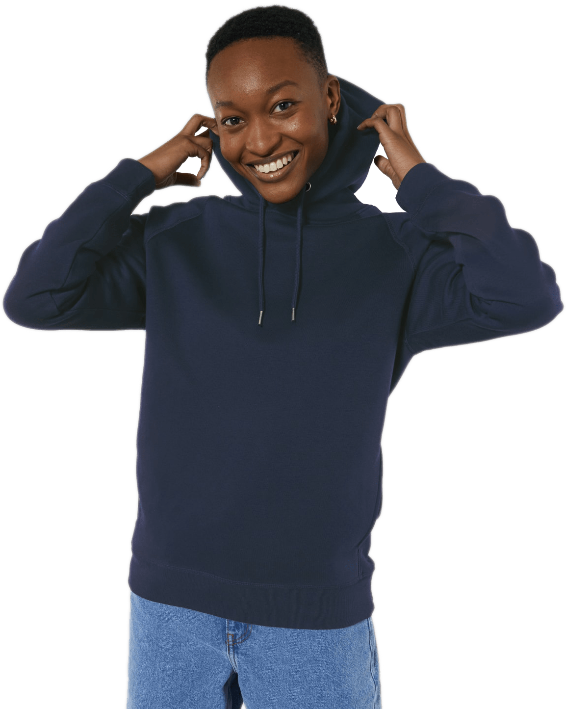 Lächelnde Person in dunkelblauem Hoodie und Jeans, Hände an der Kapuze