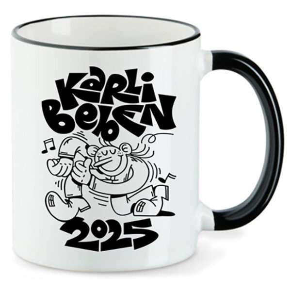 Weißer Becher mit schwarzem Henkel, schwarzem Cartoon tanzender Figur und Schrift Karli Belsen 2025.