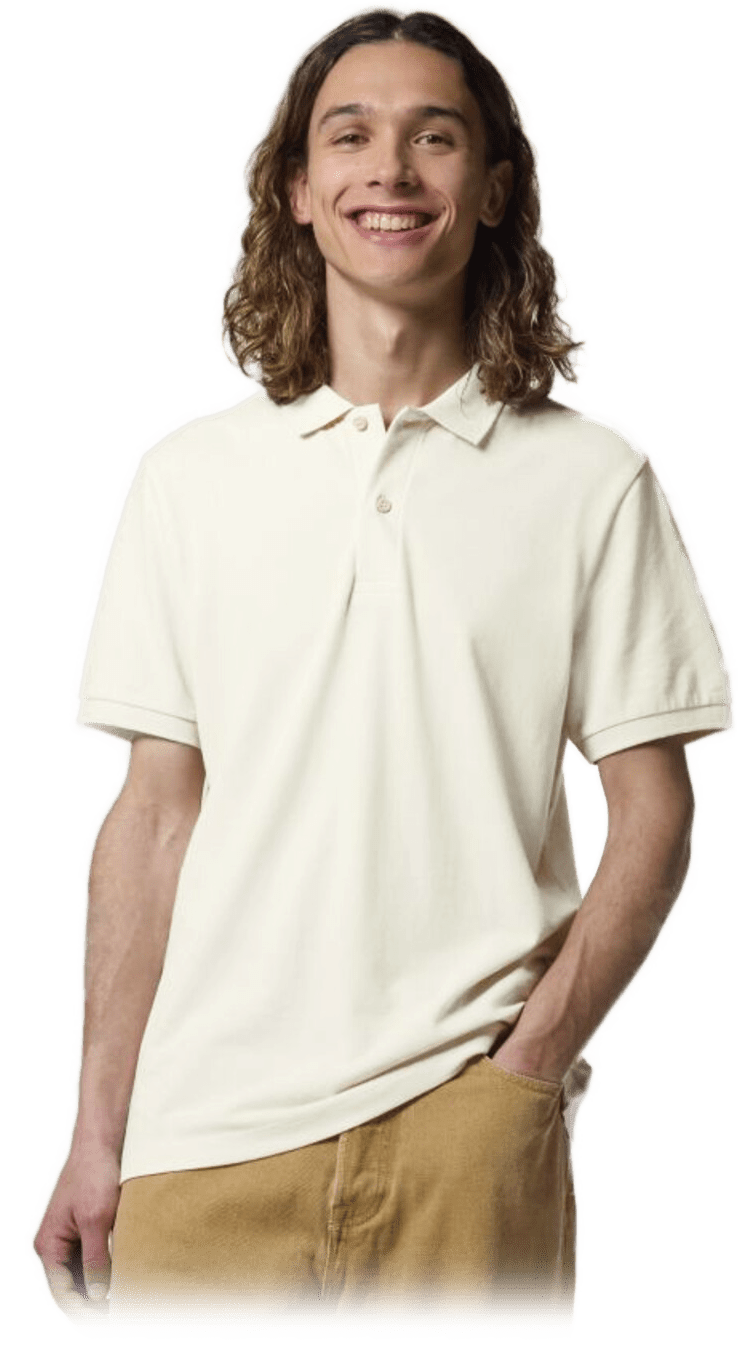 Lächelnder junger Mann mit schulterlangem Haar in cremefarbenem Poloshirt und beiger Hose, eine Hand in der Tasche.