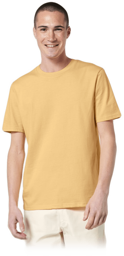 Junger Mann mit kurzem Haar lächelt, trägt gelbes T‑Shirt und helle Shorts vor neutralem Hintergrund.