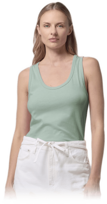 Blonde Frau in mintgrünem Tanktop und weißer Hose, frontal stehend.